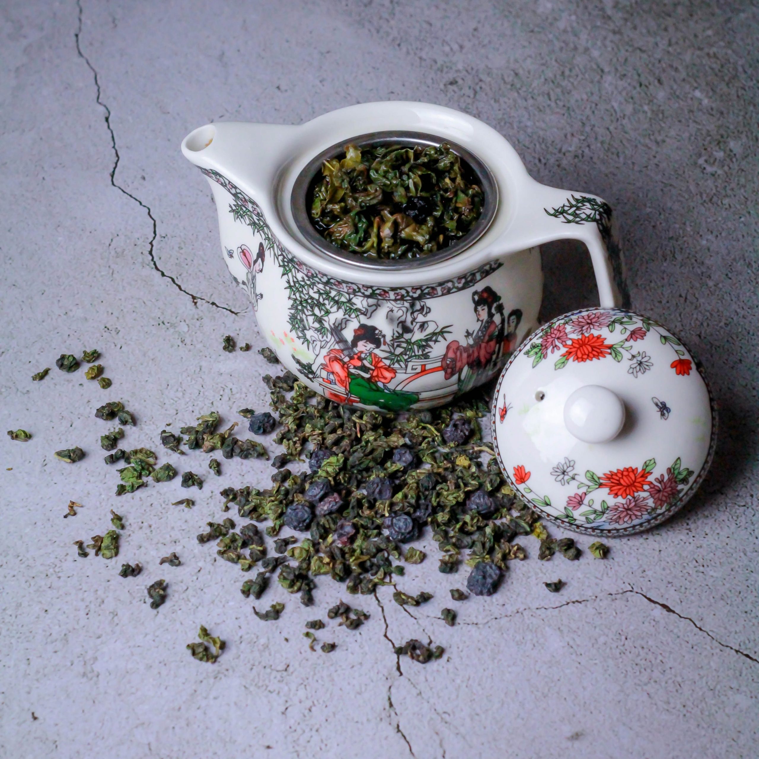Teapot with printed art filled with Oolong tea leaves